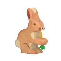 Handgeschilderd houten haasje van Holztiger met een oranje wortel in zijn pootjes, duurzaam speelgoed verkrijgbaar bij Het Speellab in Dwingeloo.