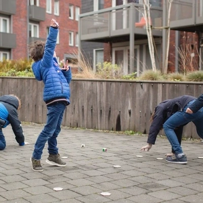 Kinderen die op het schoolplein het beestjes zoekspel van BS Toys spelen 