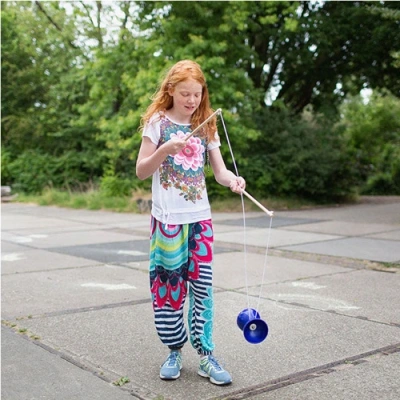 Kind speelt met BS Toys Diabolo Blauw in de tuin