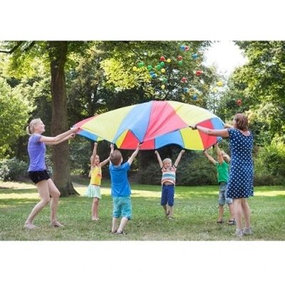 Kinderen spelen met BS Toys parachute vang- en werpspel buiten in park