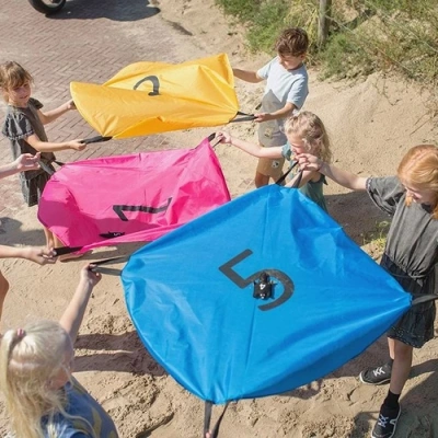 Kinderen spelen actief buitenspel met eekhoorn parachutes