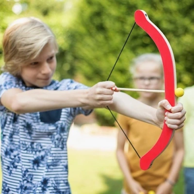 Jongen die houten pijl van pijl en boog spel BS toys schiet
