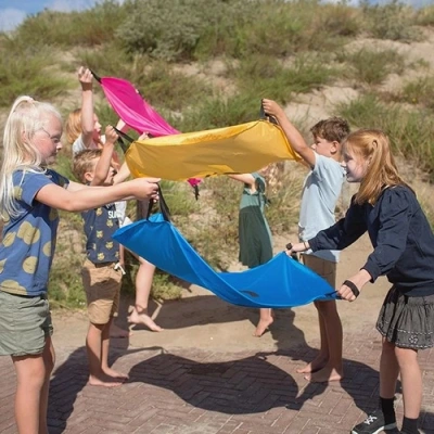 Kinderen spelen samen actief buitenspel met eekhoorn parachutes bs toys