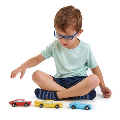 Kleurrijke houten vintage speelgoedautos van Tender Leaf Toys tijdens open einde spel met jongen op de grond